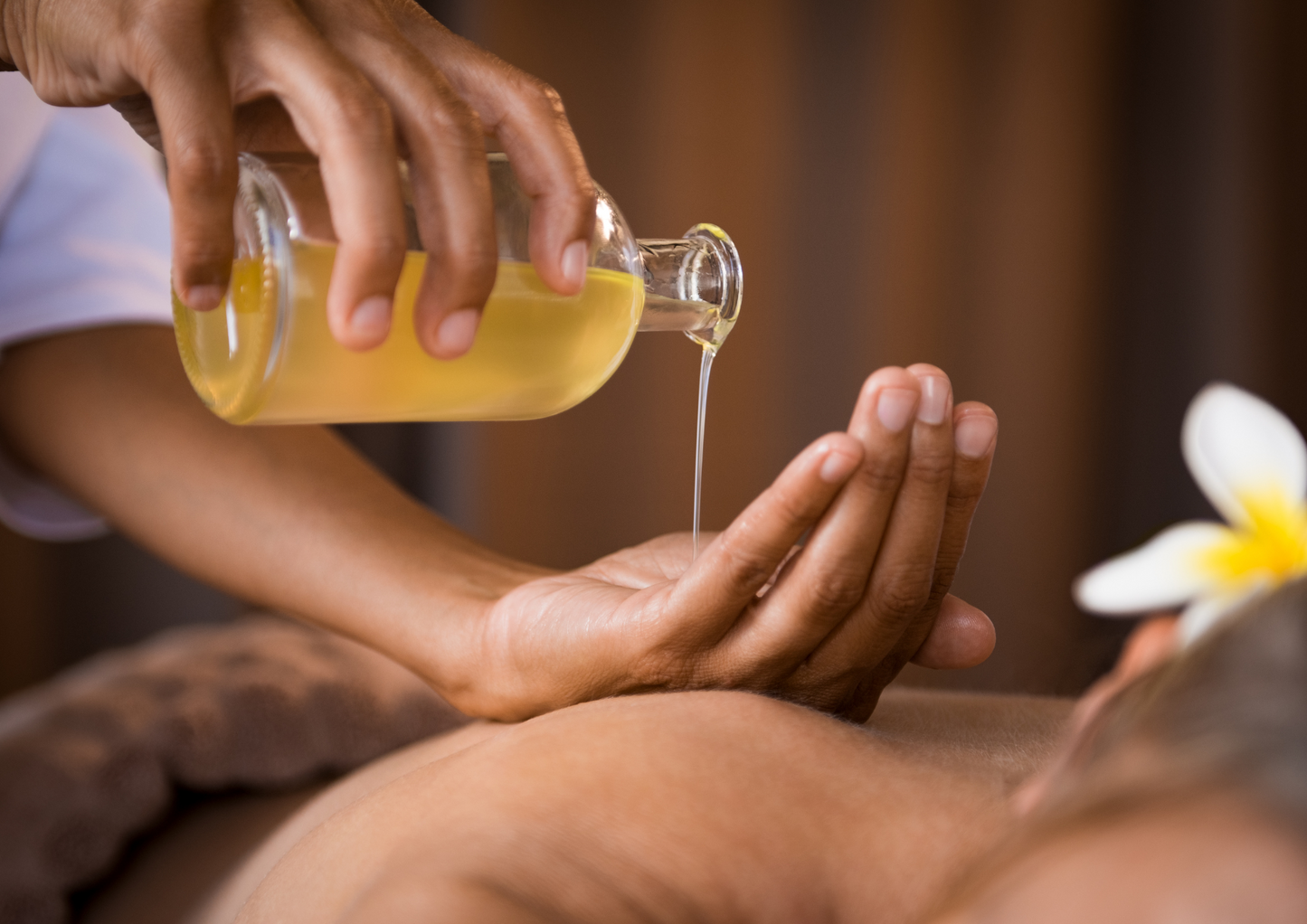 massage therapist using warm oil