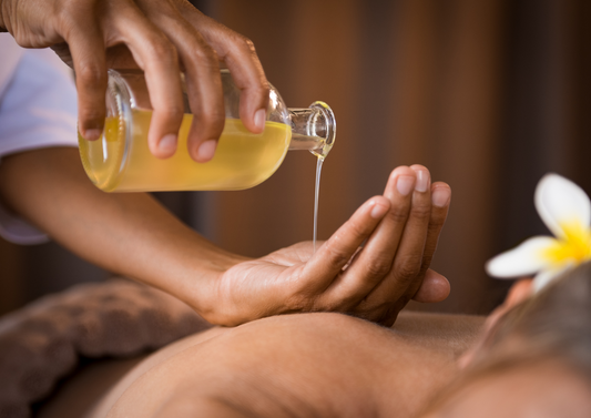 massage therapist using warm oil 